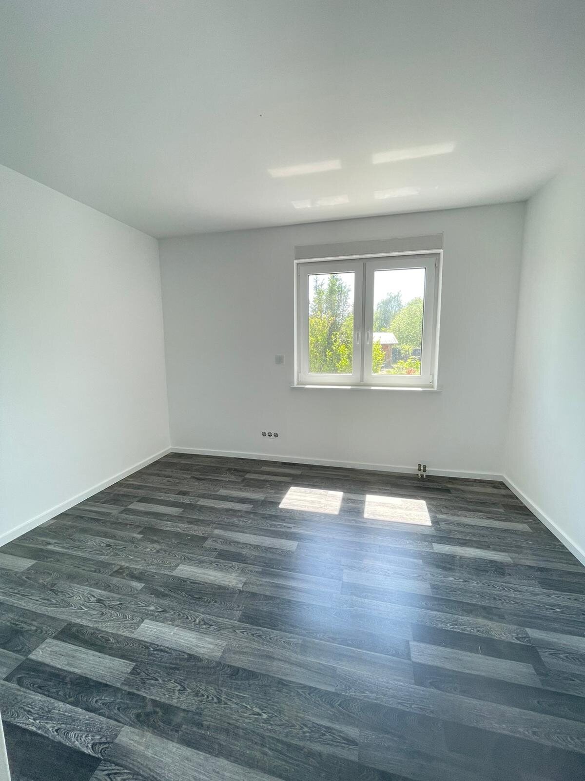 Fertig renovierter Wohnraum mit dunklem Boden
